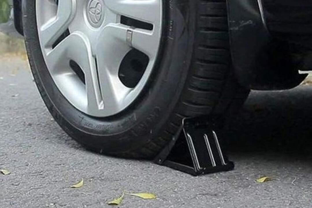 Cố định bánh xe bằng gạch ven đường hoặc dụng cụ chuyên dùng